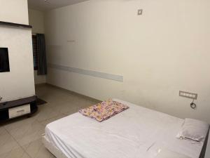 a room with a bed with a pillow on it at S G S LOADGING aND BOARDING in Dod Ballāpur