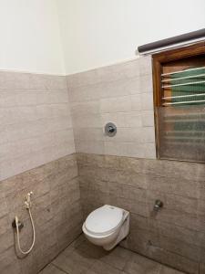a bathroom with a toilet and a window at S G S LOADGING aND BOARDING in Dod Ballāpur