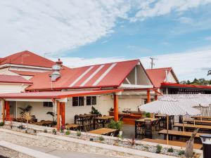a restaurant with tables and umbrellas outside of it at Commercial Hotel Boonah in Boonah