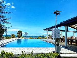a swimming pool with the ocean in the background at Pini Villa in Ampara