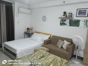 a living room with a bed and a couch at Pamz Studio Condo Unit in Lapu Lapu City