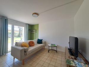 a living room with a couch and a flat screen tv at Gîtes de l'AKWABA hébergements T2 et T3 et 1 chambre à la nuitée in Buzet-sur-Baïse