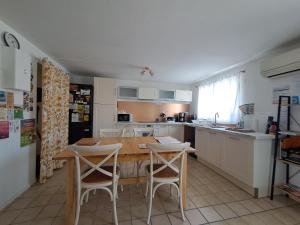 a kitchen with a table and two chairs and a table and a kitchen at Gîtes de l'AKWABA hébergements T2 et T3 et 1 chambre à la nuitée in Buzet-sur-Baïse