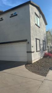 a white house with a garage and a driveway at Penn Signature Airport Short Term Rental PHX in Phoenix