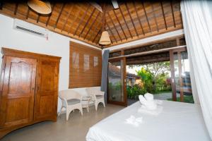 a room with a bed and a table and chairs at Harmony Heaven Ubud by The Travel Ubud Bali in Ubud