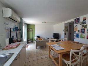 a kitchen and dining room with a wooden table at Gîtes de l'AKWABA hébergements T2 et T3 et 1 chambre à la nuitée in Buzet-sur-Baïse