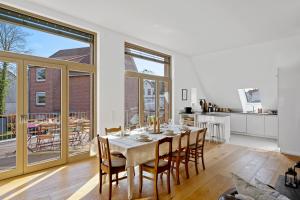 a kitchen and dining room with a table and chairs at ACKERBÜRGERHAUS - Historische Ferienwohnung mit 4 Schlafzimmern, Kamin, Sauna, Balkon-Terasse, Altstadt und See 5 Min zu Fuß, Moderne Küche, Parkplatz, WLAN in Eutin