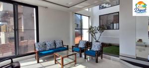 a room with chairs and a table and windows at Digant Home Retreat in Nevra