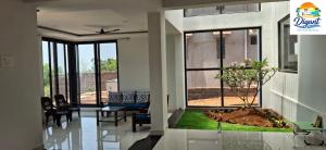 a living room with a couch and a tree in the middle at Digant Home Retreat in Nevra