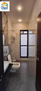 a bathroom with a toilet and a sink and a window at Digant Home Retreat in Nevra +35 photos