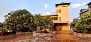 a building with a tower and trees in front of it at Digant Home Retreat in Nevra
