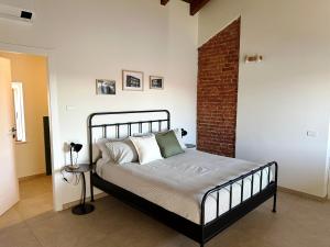 a bedroom with a bed and a brick wall at B&B Il Rosmarino in Galliate +10 photos