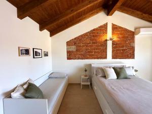 a room with two beds and a brick wall at B&B Il Rosmarino in Galliate