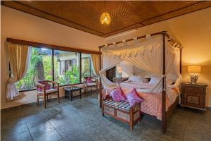 ein Schlafzimmer mit Himmelbett in einem Zimmer in der Unterkunft Rambutan Hotel in Lovina + 67 Fotos
