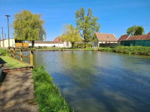 a river with buildings in the background at Au pré de Mimi in Lalande-en-Son +5 photos