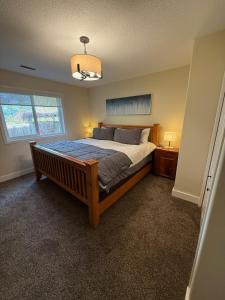 a bedroom with a bed and a window at Tall Trees Departure Bay Nanaimo in Nanaimo