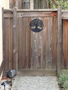a wooden fence with a gate with a tree on it at Tall Trees Departure Bay Nanaimo in Nanaimo