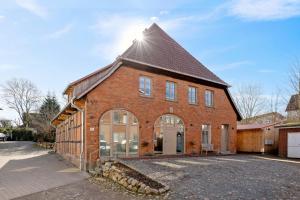 a large brick building with a pointed roof at ACKERBÜRGERHAUS - Historische Ferienwohnung mit 4 Schlafzimmern, Kamin, Sauna, Balkon-Terasse, Altstadt und See 5 Min zu Fuß, Moderne Küche, Parkplatz, WLAN in Eutin