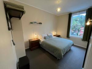a bedroom with a large bed and a window at Nourish Reefton & Wilsons Hotel in Reefton