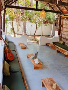 a room with a guitar and a table with a laptop at Wave Hunters Arugam Bay in Arugam Bay