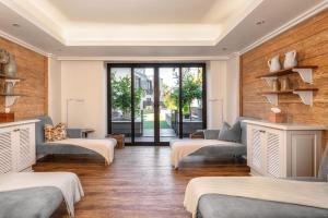 a room with three beds and a window at Strand Hotel Swakopmund in Swakopmund +85 photos
