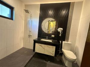 a bathroom with a toilet and a sink and a mirror at Cambridge Guest House in Mandaue City