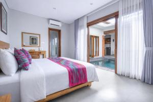 a bedroom with a bed and a swimming pool at Villa Bawa in Ubud