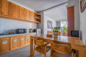 a kitchen with wooden cabinets and a wooden table and chairs at Villa Bawa in Ubud
