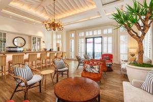 a living room with chairs and a table and a bar at Strand Hotel Swakopmund in Swakopmund