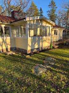 ein kleines weißes Haus mit einem Rasen davor in der Unterkunft Kalvsvik in Värmdö