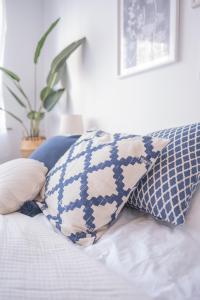 a bed with blue and white pillows and a plant at Studio charmant au centre-ville in Charleroi