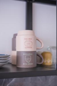 a couple of coffee mugs sitting on a shelf at Studio charmant au centre-ville in Charleroi