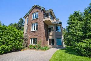 a brick building with trees in front of it at Hampton Luxe House in Coquitlam