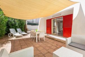 a patio with a table and chairs and a building at 066 Le Fontanelle by SalentoInVacanzaCOM in Fontanelle
