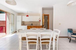 a kitchen and dining room with a white table and chairs at 066 Le Fontanelle by SalentoInVacanzaCOM in Fontanelle