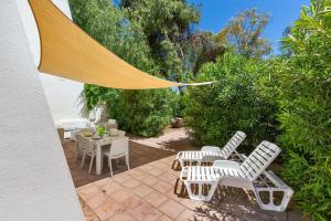 a patio with white chairs and a table at 066 Le Fontanelle by SalentoInVacanzaCOM in Fontanelle