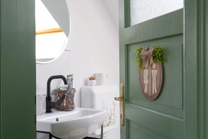 a bathroom with a green door and a sink at Mese Szálló in Lăzarea +73 photos