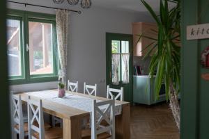 a dining room with a table and chairs and a plant at Mese Szálló in Lăzarea
