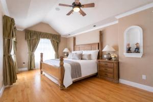 a bedroom with a bed and a ceiling fan at Hampton Luxe House in Coquitlam