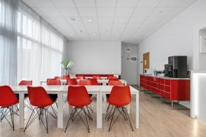 a conference room with red chairs and a white table at ASKA Heiðmörk in Reykjavík