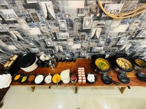 a table full of bowls and plates of food at Hotel Stayzzy Bloom in Noida