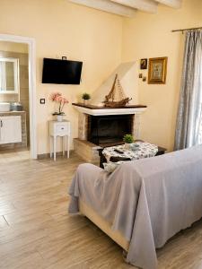 a living room with a bed and a fireplace at Logaki house in Vlachopoulátika