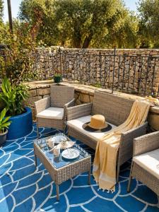 a patio with wicker chairs and tables on a blue floor at Logaki house in Vlachopoulátika