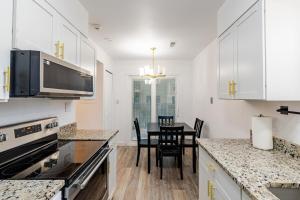 a kitchen with white cabinets and a table with chairs at The Chautard Suite in Pueblo