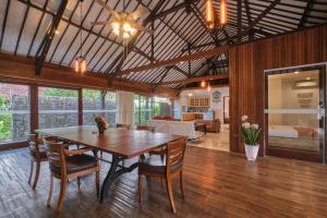 a dining room with a wooden table and chairs at Miko Villas Ubud in Ubud