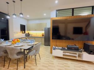 a living room with a table with chairs and a television at Villa Dietze in Davao City