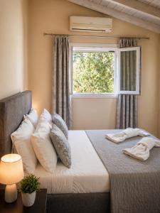 a bedroom with a large bed with a window at Logaki house in Vlachopoulátika