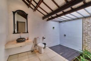 a bathroom with a toilet and a mirror at Miko Villas Ubud in Ubud +10 photos