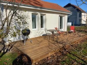 a wooden deck with a grill and a table and chairs at Rever la Saône in Rigny