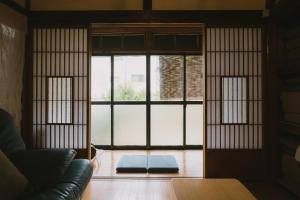 a living room with a large window and a couch at Kominka Hakone Entire Traditional House in Hakone